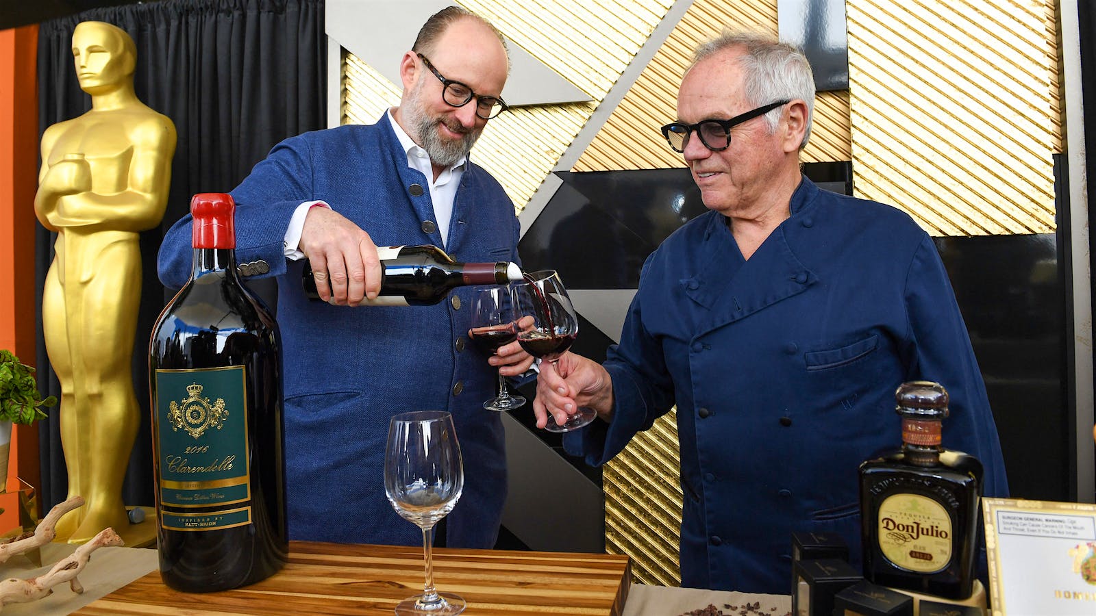 Prince Robert de Luxembourg (left) shares a pour of 2016 Clarendelle with chef Wolfgang Puck at the 2023 Academy Awards Governors Ball.