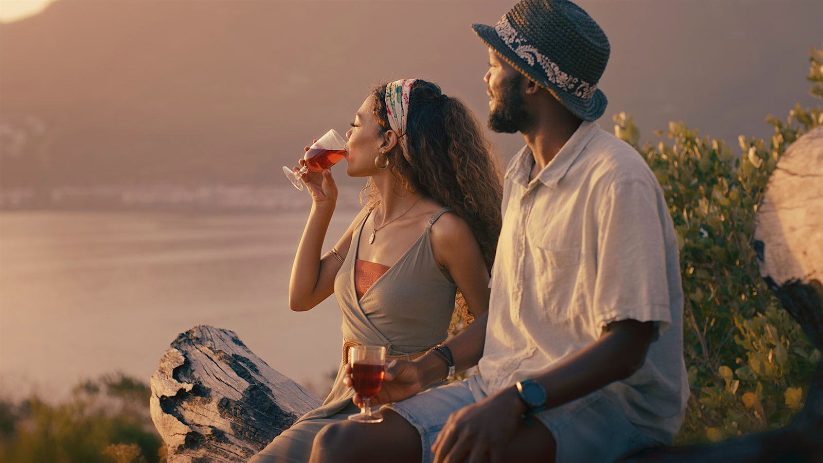 Woman and man drinking red wine on the beach