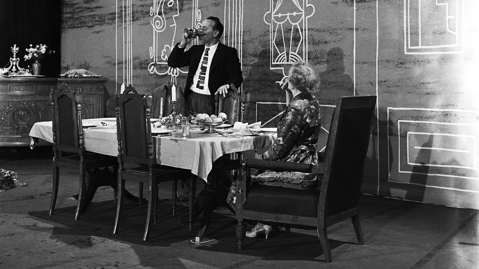 A scene from the 1963 performance of "Dinner for One," with Freddie Frinton as Butler James drinking from the wine glass of another "guest" to keep May Warden as Miss Sophie company